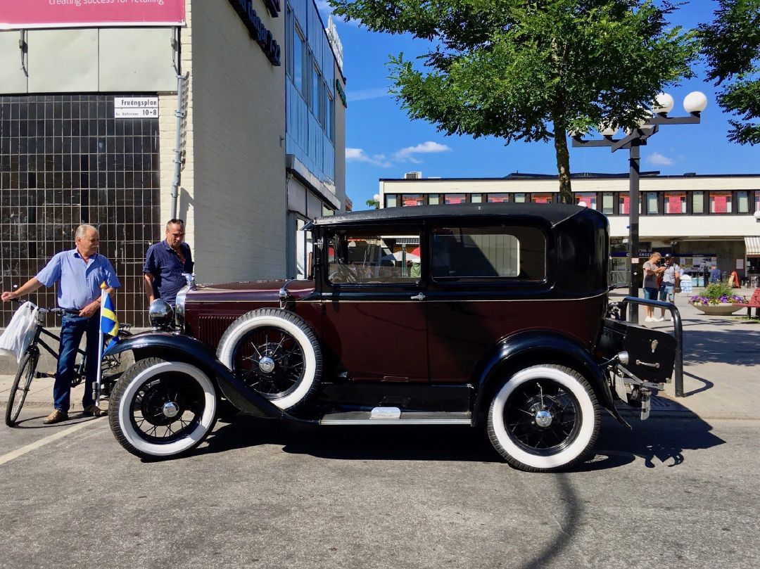 Ford Model A tengah parkir di depan Stasiun Fruängen; modelnya mirip dengan mobil pada sampul buku mewarnai favorit saya.